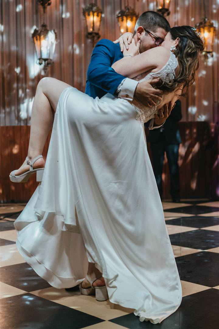 A couple shares a dip on a black and white checkered dance floor